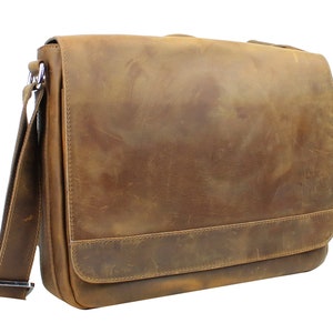 May include: A brown leather messenger bag with a long adjustable strap. The bag has a flap closure and a single pocket on the front.