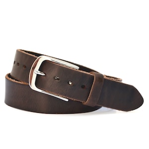 May include: A brown leather belt with a silver buckle. The belt is folded in half and the buckle is visible in the center of the image.