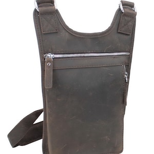 May include: A brown leather crossbody bag with a zippered pocket and a silver zipper pull. The bag has a long adjustable strap.