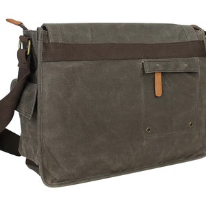 May include: A brown canvas messenger bag with a brown leather strap and a brown leather flap. The bag has a large pocket on the front with a brown leather flap and a metal snap closure.