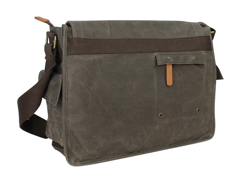 May include: A brown canvas messenger bag with a brown leather strap and a brown leather flap. The bag has a large pocket on the front with a brown leather flap and a metal snap closure.