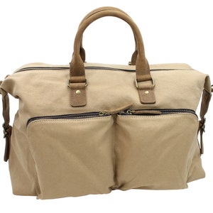 May include: A beige canvas travel bag with brown leather handles and trim. The bag has two zipped pockets on the front.