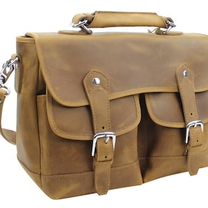 May include: A brown leather messenger bag with two front pockets and a buckle closure. The bag has a top handle and an adjustable shoulder strap.