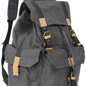 May include: A gray canvas backpack with brown leather accents and buckles. The backpack has a large main compartment and a smaller front pocket.