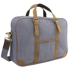 May include: A gray canvas and brown leather briefcase with a top handle and a shoulder strap. The bag has a front pocket and two buckles on the front.