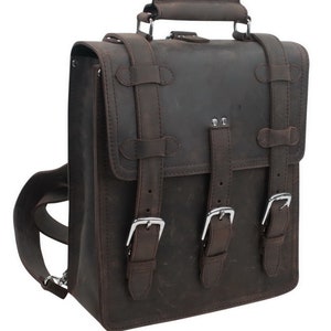 May include: A brown leather backpack with multiple buckles and straps. The backpack has a top handle and a flap closure.