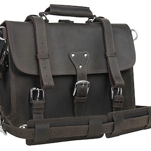 Può includere: Una valigetta in pelle marrone con più cinturini e fibbie. La borsa ha una maniglia superiore e una tracolla.