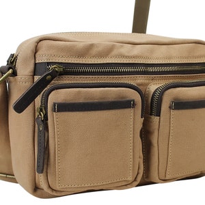 May include: A tan canvas messenger bag with brown leather accents and multiple zippered pockets.