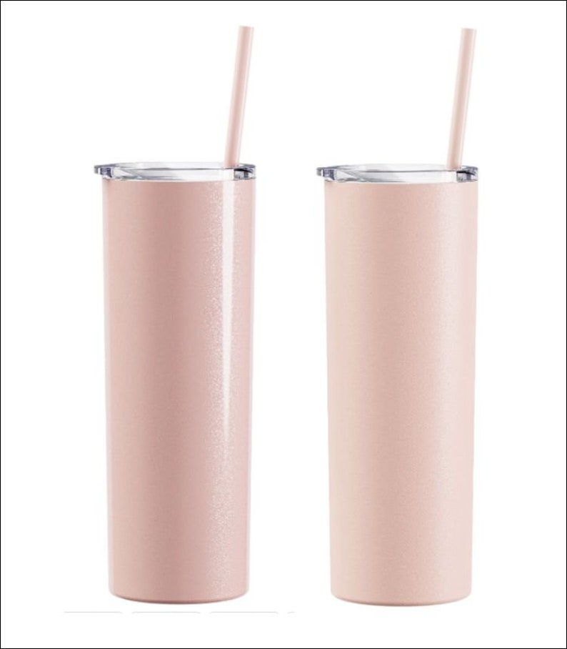 May include: Two pink insulated tumblers with clear lids and matching straws. The tumblers have a slender, cylindrical shape and a subtle glittery finish. The straws are inserted through the lids, ready for use. The background is plain white.