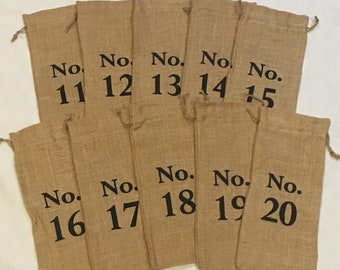 May include: Twenty brown burlap bags with black numbers from 11 to 20 printed on them.