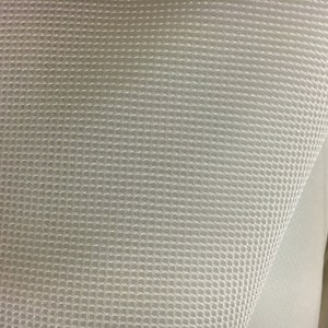 May include: Close-up of a white mesh fabric with a fine, even weave. The fabric is slightly wrinkled and has a soft, pliable texture.