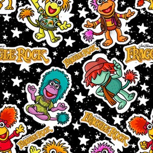 May include: A repeating pattern featuring colorful cartoon characters from Fraggle Rock on a black background with white stars. The characters are in various poses, with the words "FRAGGLE ROCK" in a gold font.