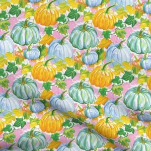 Könnte beinhalten: Ein nahtloses Muster mit blauen und gelben Kürbissen auf rosa Hintergrund. Die Kürbisse sind in Aquarelltechnik mit grünen Blättern und Ranken gemalt.