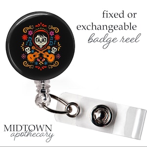 Puede incluir: Portatarjetas negro con un diseño colorido del Día de Muertos. El diseño presenta una calavera, guitarras y elementos florales. El texto "fixed or exchangeable badge reel" es visible. El portatarjetas tiene una correa blanca y un clip metálico.