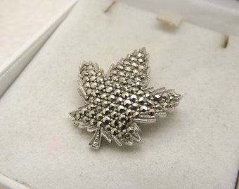 A lovely Keyes of Canada maple leaf vintage jewelry brooch made in silvertone engraved metal set with sparkly round marcasite stones