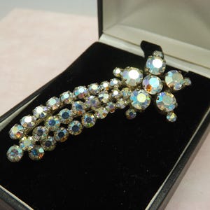 A superb shooting star design vintage costume brooch in silvertone metal set with mixed size round sparkly rainbow coloured faceted stones