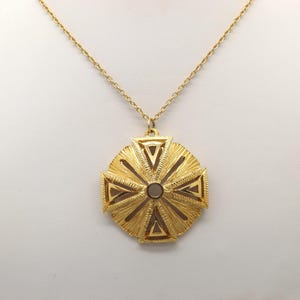 A beautiful &#39; Sphinx &#39; round fancy vintage costume jewelry pendant with chain made in polished and patinated raised openwork goldtone metal