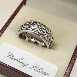 A fine 925 silver floral band style vintage jewelry dress or signet ring decorated in a pierced and engraved flower design all round outside