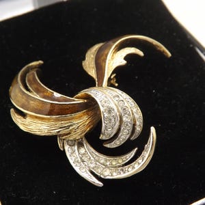 Eine schöne abstrakte Swirl Brosche von Attwood and Sawyer aus goldfarbenem Metall mit brauner Emaille und mit klaren, weißen Steinen besetzt