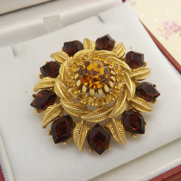 A beautiful early Sphinx flower design vintage jewelry brooch in fine goldtone metal with sparkly brown and yellow stones