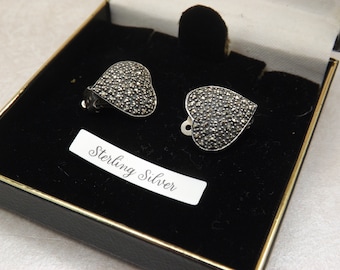 A lovely 925 solid silver pair of heart shape vintage jewelry clip on earrings made in a polished silver set with sparkly marcasite stones.