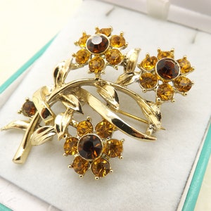 A superb flower spray goldtone vintage jewelry brooch set with sparkly deep rich yellow and brown faceted round glass stones