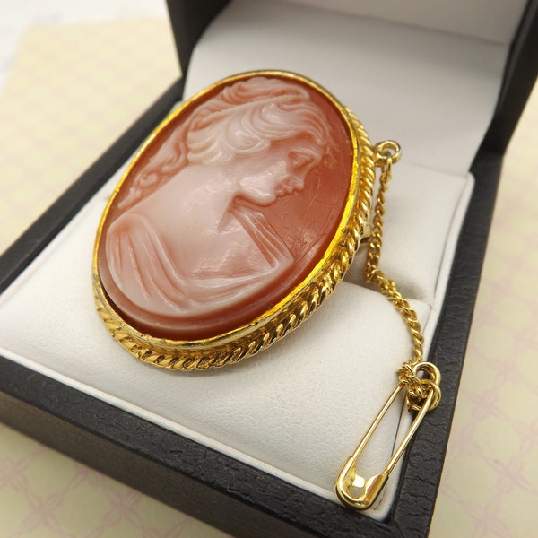 A superb Exquisite cameo vintage costume jewelry brooch made of goldtone metal  set with a faux cameo of a young maiden