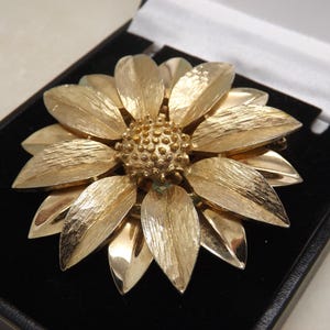 A vey fine Sarah Coventry Canada large round flower head design vintage jewelry brooch in polished and patinated openwork goldtone metal