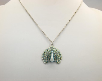 A beautiful peacock design vintage jewelry pendant and chain made in silvertone metal and decorated with mixed enamels and coloured stones