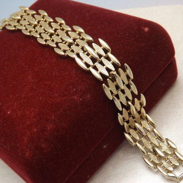 A very fine Sarah Coventry Canada wide bar style design vintage jewelry bracelet made in polished and patinated openwork goldtone metal