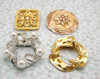 A superb group of four goldtone and silvertone mixed design vintage jewelry scarf clips in various colours, shapes, finishes and sizes