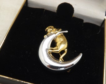 Broche de bisutería con un precioso gatito trepando sobre la luna diseñado y realizado en plata pulida y metal dorado.
