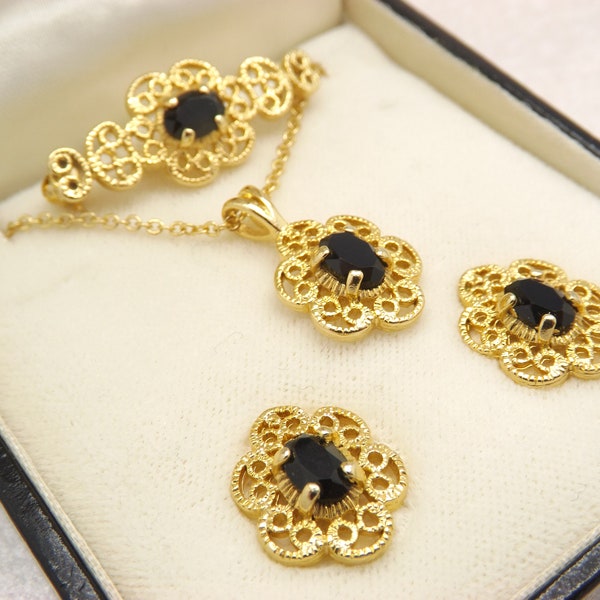 A Zales jewellers goldtone costume jewelry necklace, pierced earrings and brooch set made in goldtone metal set with sparkly black stones