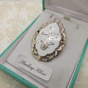 A very fine period classic Siam / Thai dancer oval design vintage jewelry brooch made in openwork silver and white enamel