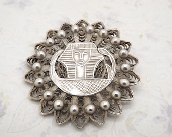 A beautiful handmade Egyptian vintage jewelry brooch made in unmarked Egyptian silver with the design of the head of a Pharaoh in the center