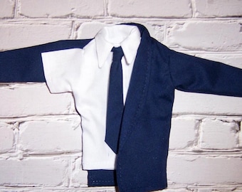 May include: A white dress shirt with a dark blue tie and a dark blue blazer. The blazer is unbuttoned and the shirt is visible underneath.