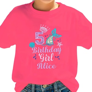Könnte beinhalten: Ein leuchtend pinkfarbenes T-Shirt mit einem Meerjungfrauen-Design. Das Design umfasst eine Krone, die Zahl 5, eine Meerjungfrauenschwanzflosse und den Text "Birthday Girl Alice". Das Shirt besteht aus einem weichen Material.