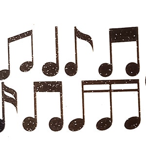 May include: A set of black glitter musical notes and a treble clef. The notes are in various sizes and shapes, and the treble clef is large and ornate.
