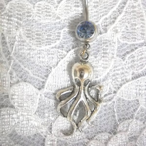 May include: Silver belly button ring with a blue gem and an octopus charm.
