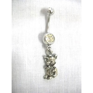 May include: Silver belly button ring with a clear crystal and a dangling pig charm.