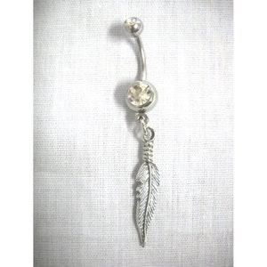 May include: Silver belly button ring with a clear crystal and a dangling feather charm.