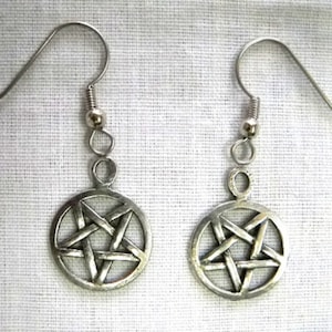 May include: A pair of silver earrings with a pentagram design. The earrings are made of metal and have a simple, elegant design.
