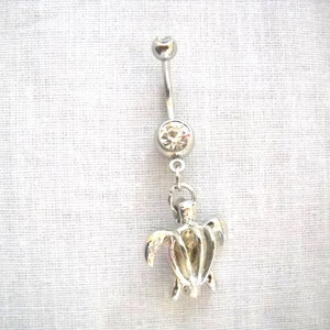 May include: Silver belly button ring with a clear crystal and a dangling turtle charm.