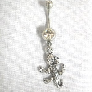 May include: Silver belly button ring with a clear crystal and a silver lizard charm.