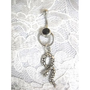 May include: A silver body piercing with a black gem and a dangling snake charm.