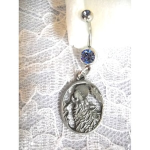 May include: A silver belly button ring with a blue gem and a charm featuring a wolf howling at the moon.