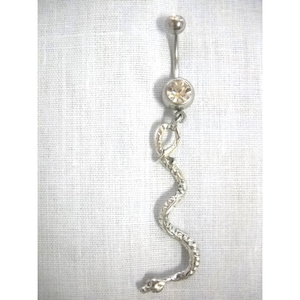 May include: Silver belly button ring with a clear crystal and a dangling snake charm.