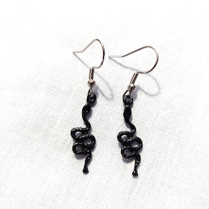 May include: A pair of black snake dangle earrings with silver hooks.