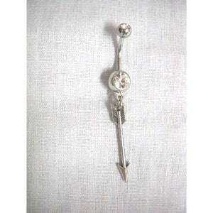 May include: Silver belly button ring with a clear crystal and a dangling arrow charm.