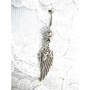 May include: Silver belly button ring with a dangling charm featuring a rose and an angel wing.